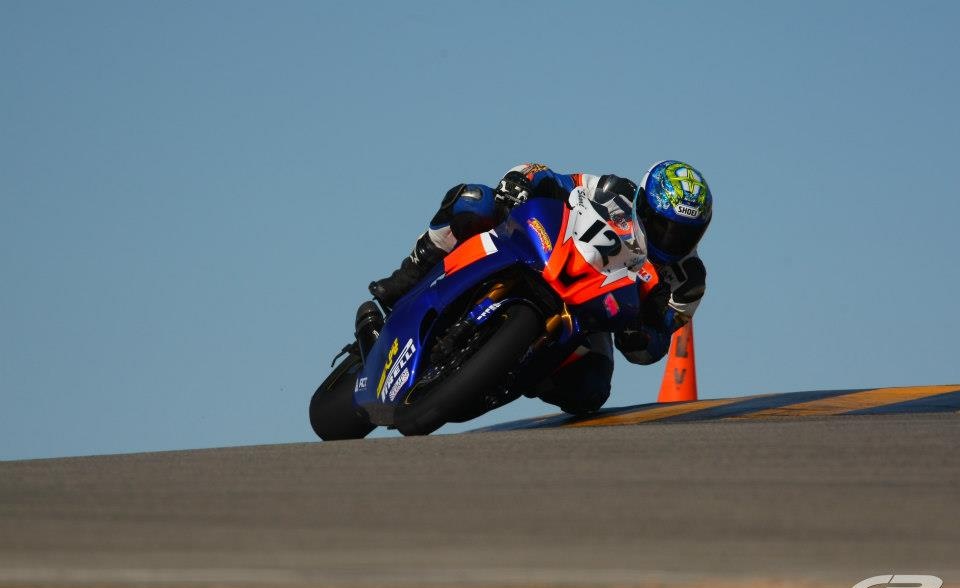 Brian Short racing number 12 on his blue and orange motorcycle at Chuckwalla Valley Raceway